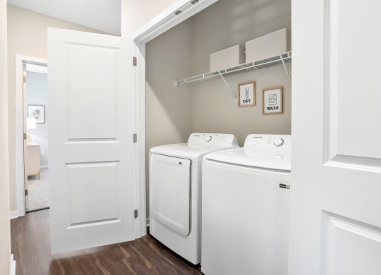 a spacious laundry room with washer and dryer and a door to the bathroom