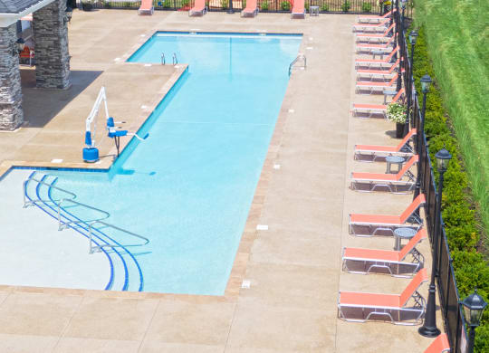 an aerial view of a swimming pool with chairs around it