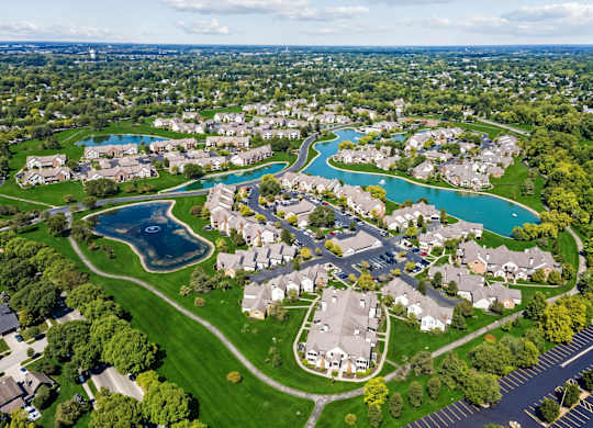A bird's eye view of a residential neighborhood with a large swimming pool.