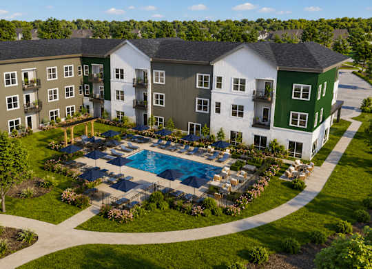 An aerial view of a resort with a swimming pool and apartment buildings.