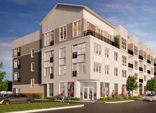 A modern apartment building with a parking lot in front.