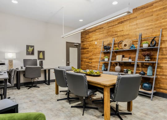 a dining room with a wooden table and chairs and a desk with a computer