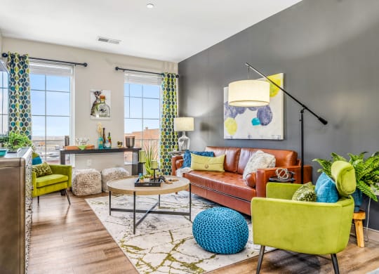 a living room with a brown couch and yellow chairs