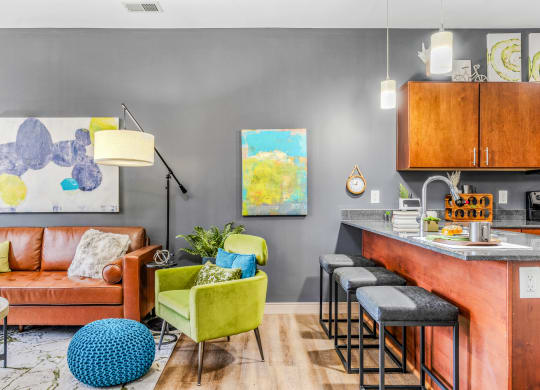 a living room with a kitchen and a couch and chairs