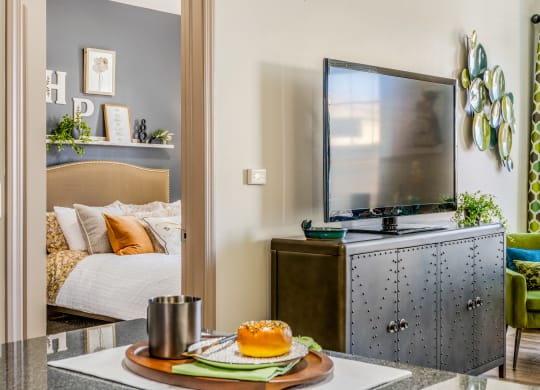 a bedroom with a tv and a table with a plate of food