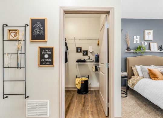 a bedroom with a bed and a closet with shelves and a door to it