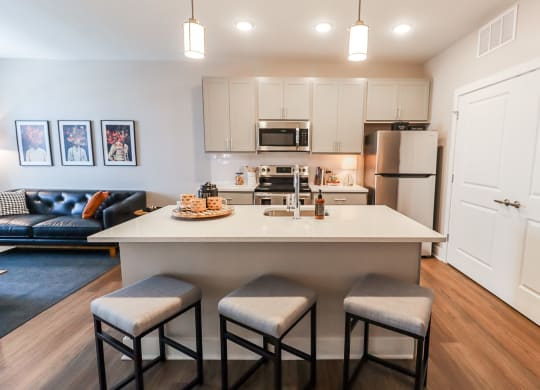 a kitchen with a large island with three stools in front of it