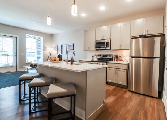 a kitchen with a large island and stainless steel appliances