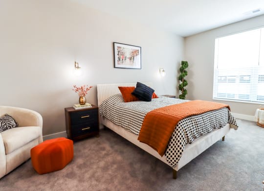 a bedroom with carpeted floors and a large window