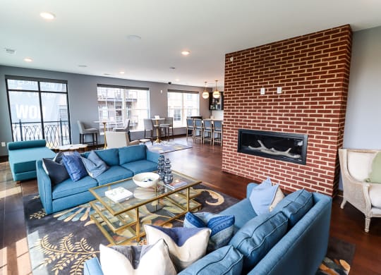 a living room with blue couches and a coffee table in front of a fireplace