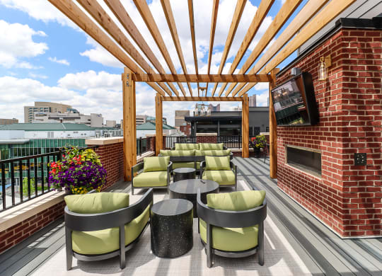 an outdoor patio with a television and tables and chairs