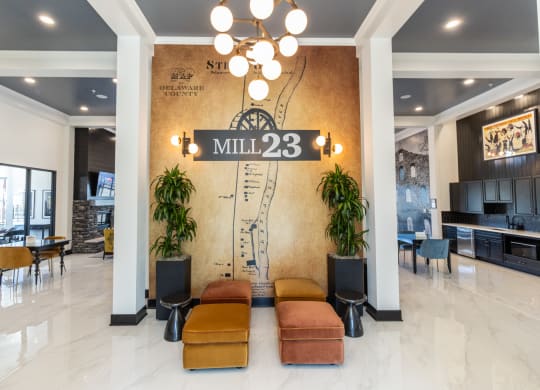 the lobby of mill 23 with couches and a wall with a sign on it