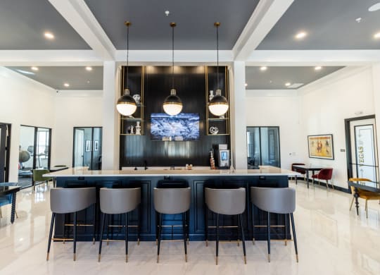 a large kitchen with a bar and chairs in front of it
