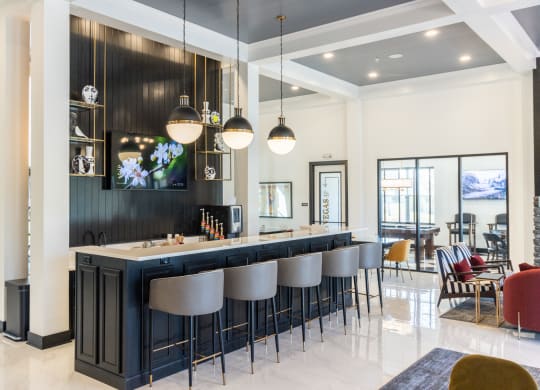 a bar with bar stools in a living room with a dining table and chairs