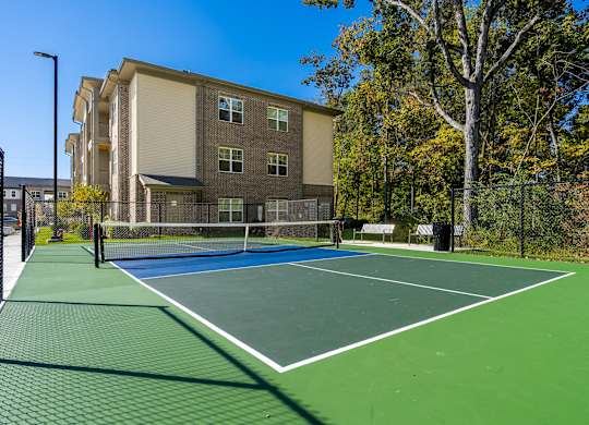 A tennis court in front of a building.