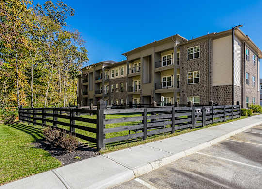 A modern apartment building with a black fence in front.
