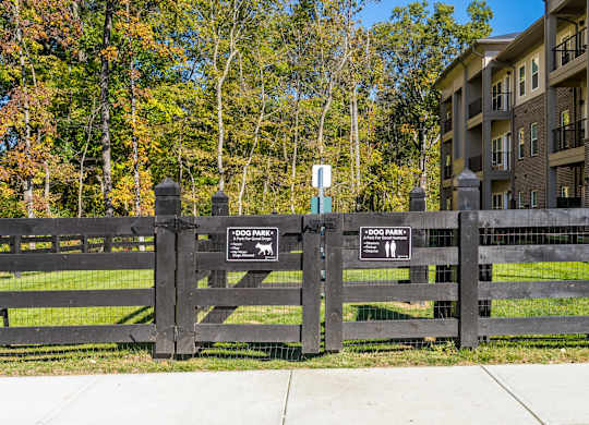 A black fence with two signs that say