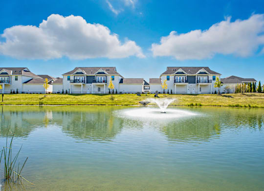A row of houses with a fountain in the foreground.