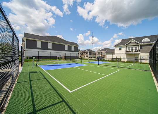 A tennis court surrounded by a black fence.