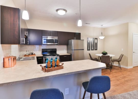 the view of a kitchen and dining room with a large counter top with a bar