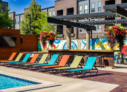 a pool area with lounge chairs and a television