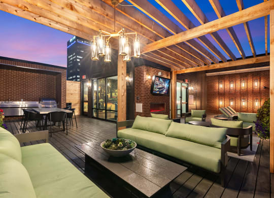 a patio with green couches and chairs and a table and chairs