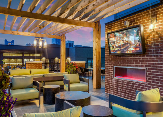 a patio with couches and tables and a fireplace