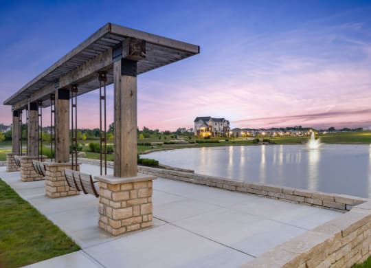 a pavilion overlooking a lake at sunset