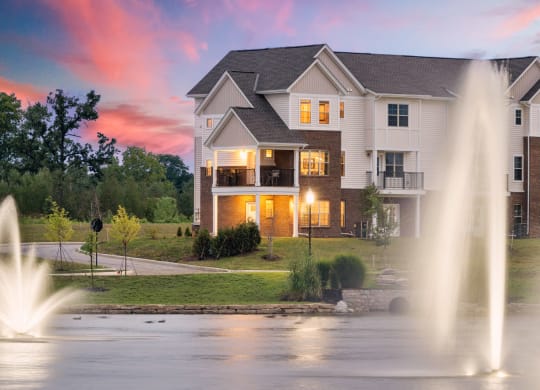 A fountain in a pond in front of The Strand at Beulah Luxury 2 bedroom Townhomes for rent in Grove City Ohio
