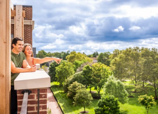 a couple standing on a balcony looking out at the view