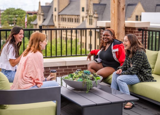 a group of women sitting around a table on a patio