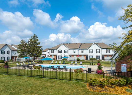 the view of a swimming pool with apartments in the background