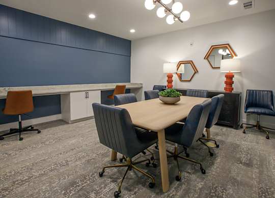 A conference room with a table, chairs, and mirrors.