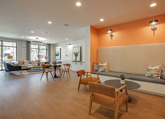 A living room with a grey couch and orange walls.