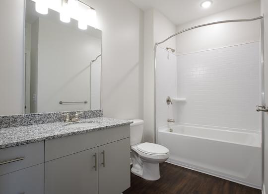 A white bathroom with a toilet, sink, and bathtub.