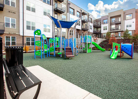 A playground with a slide, swings, and a climbing frame.