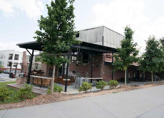 A building with a black roof and a sign that says "The Brewers" sits on a street corner.