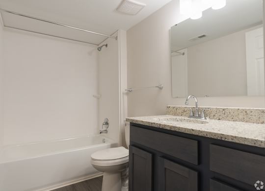 A bathroom with a toilet, sink, and bathtub.