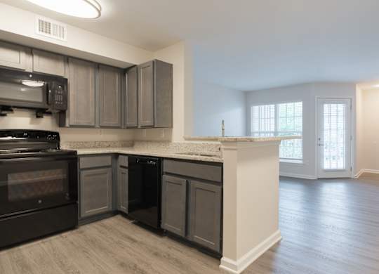 A kitchen with a black oven and microwave.