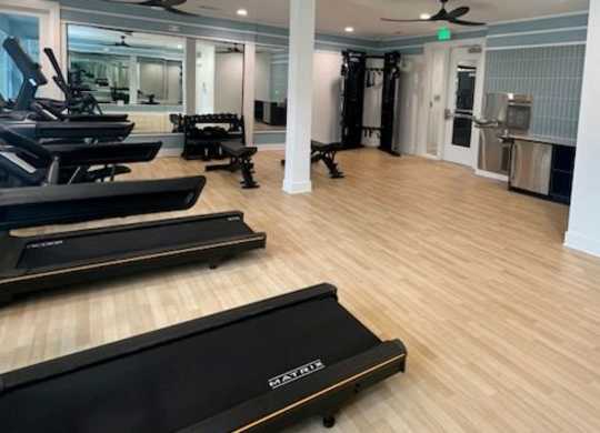 A treadmill is on the floor of a room with a ceiling fan.