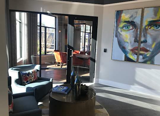 A living room with a large painting on the wall.