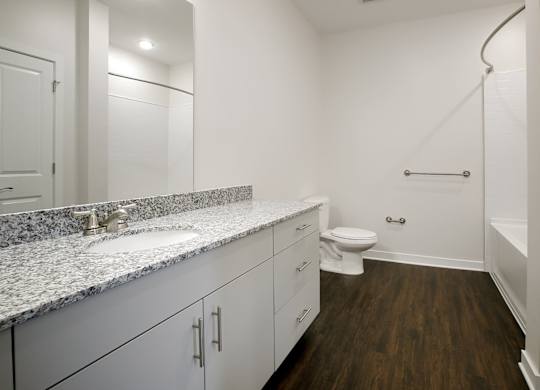 A bathroom with a toilet, sink, and a bathtub with a shower head.