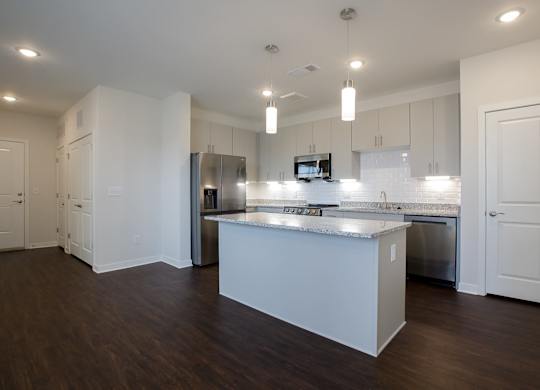 A modern kitchen with a large island and stainless steel appliances.