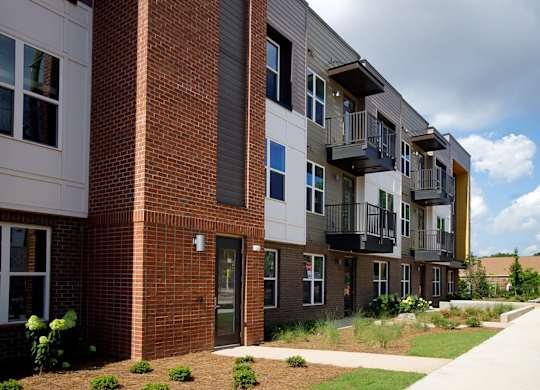 A modern apartment building with balconies and a brick facade.