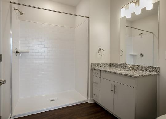 A white bathroom with a walk-in shower and a toilet.