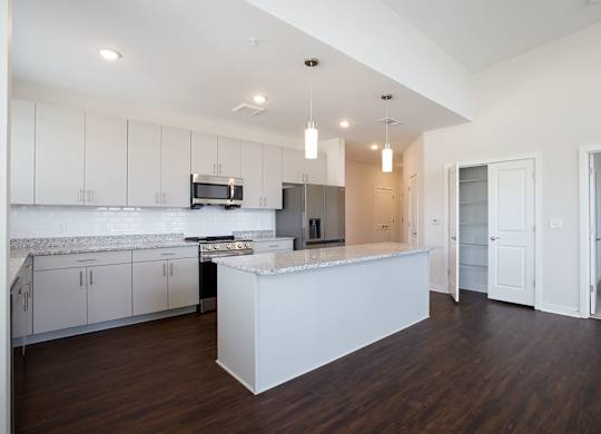 A modern kitchen with white cabinets and a central island.