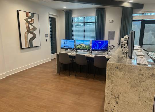 A modern office with a large desk and two monitors.