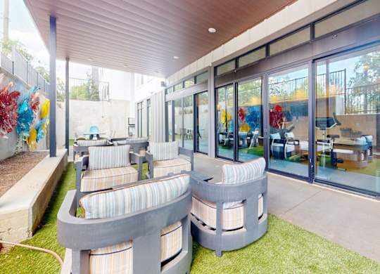 A modern outdoor seating area with a curved bench and a table.