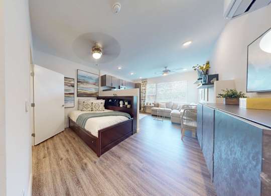 A bedroom with a bed, a chair, and a mirror.