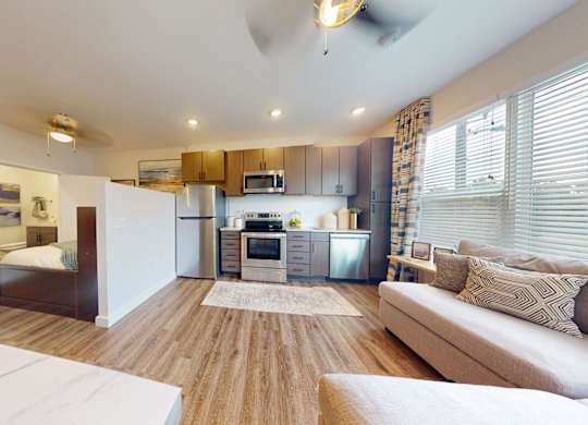 A modern living room with a white sofa and a wooden floor.